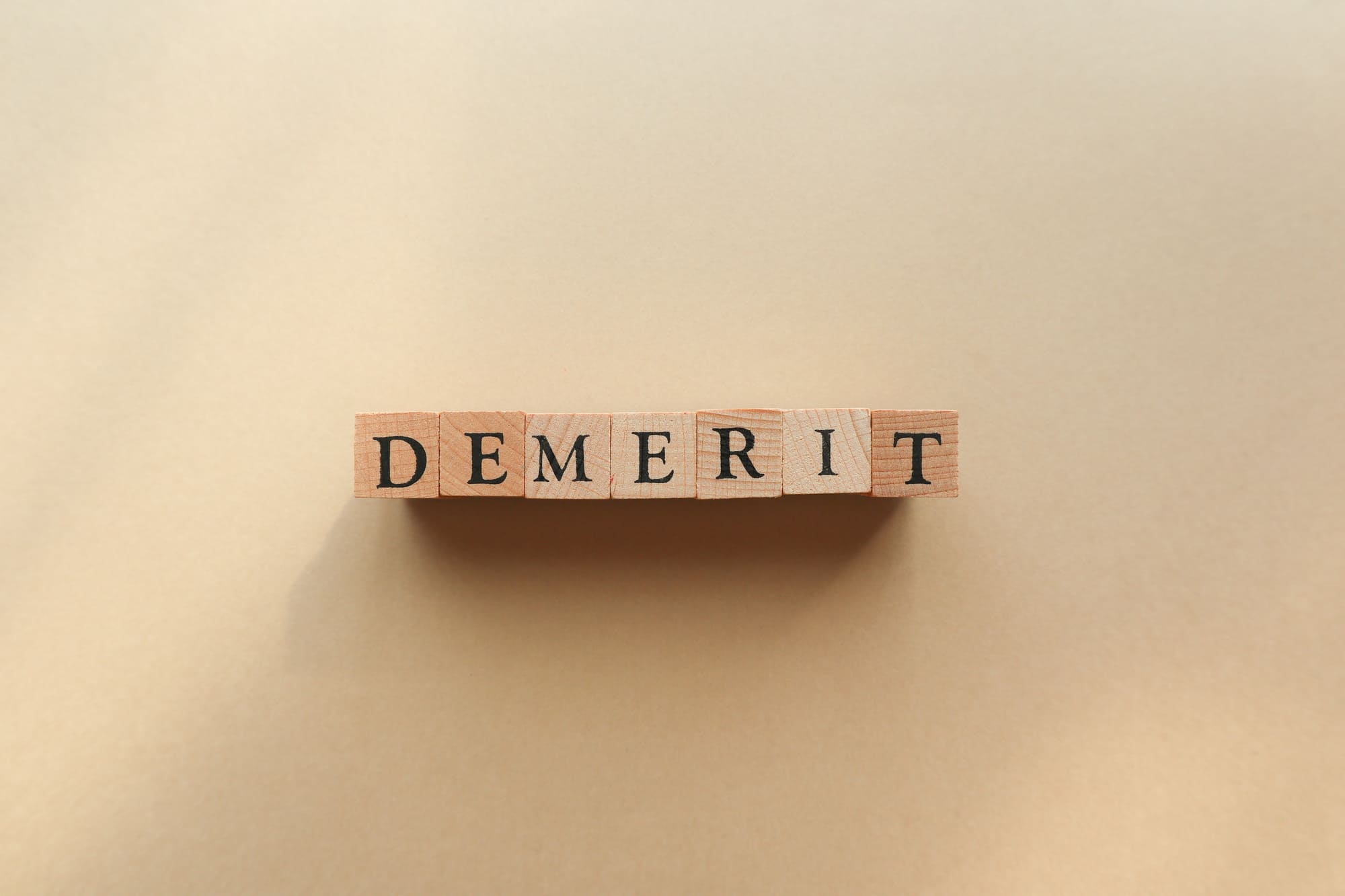 「DEMERIT」と書かれた積木